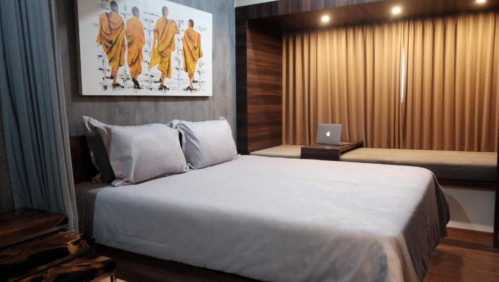 sypialnia z dużym łóżkiem i laptopem w obiekcie Lavenderbnb Room 2 at Uttara the Icon Apartment w mieście Yogyakarta