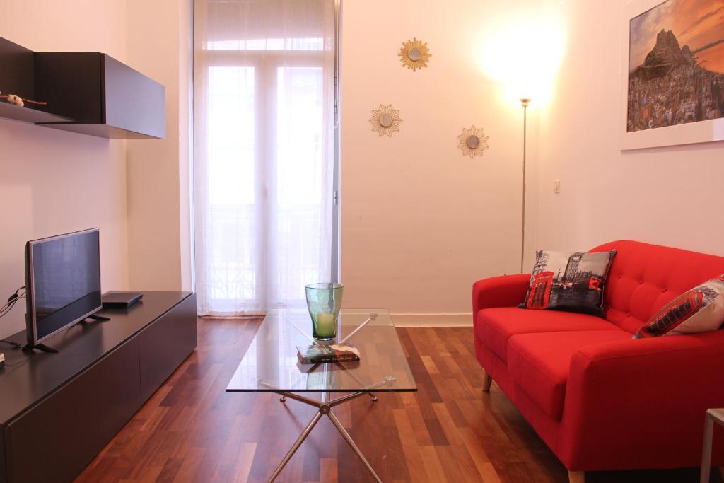 a living room with a red couch and a tv at Modern Apartment - Alicante in Alicante