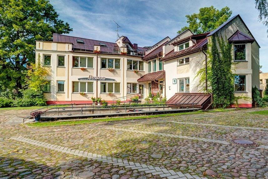 a large house with a large patio in front of it at Drusva Apartamentai in Druskininkai