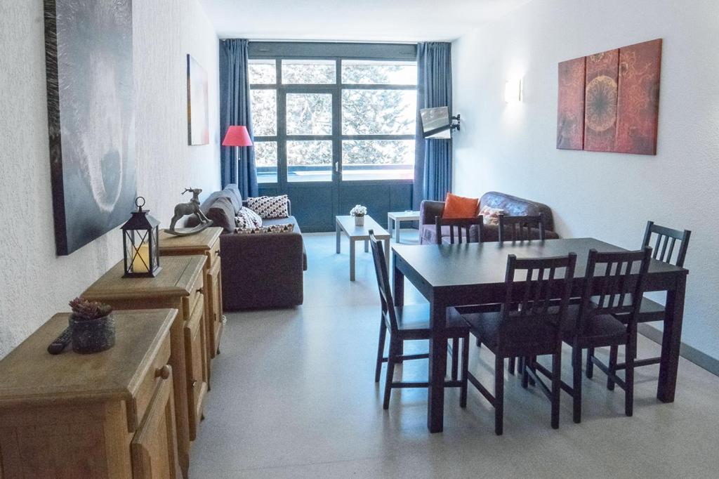a kitchen and living room with a table and chairs at Spacieux 4/6 places proche du centre in Saint-Lary-Soulan