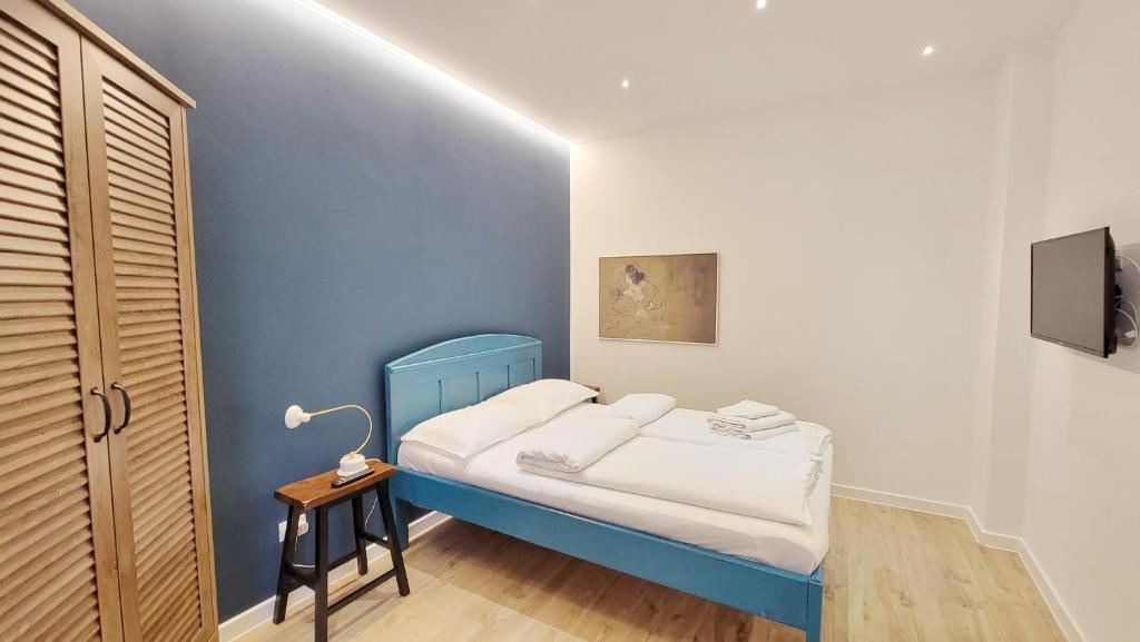 ブラショヴにあるBlack Church Apartmentの小さなベッドルーム(青いベッド1台、テーブル付)