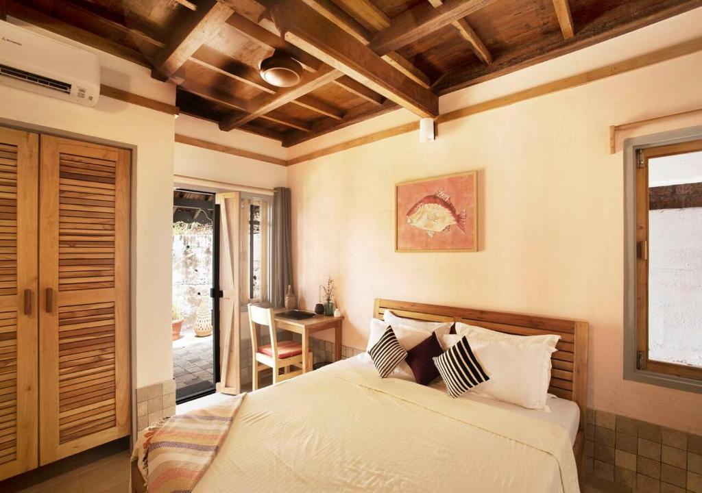 1 dormitorio con cama, mesa y ventana en SaffronStays Crescent Bay, Palshet, en Chiplun