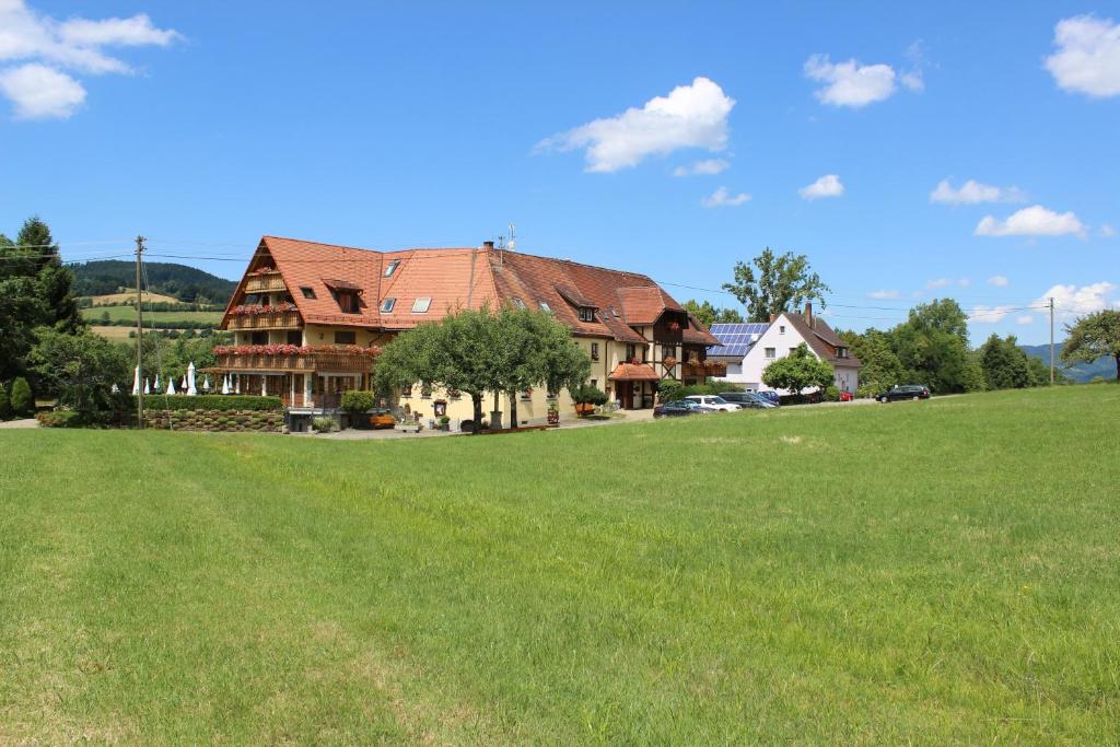 ein großes Haus mit einem grünen Feld davor in der Unterkunft Landgasthof zum Schützen in Oberried