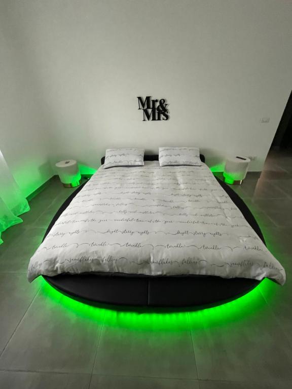 um quarto com uma cama com luz verde em Appartamento Calilla em Taranto