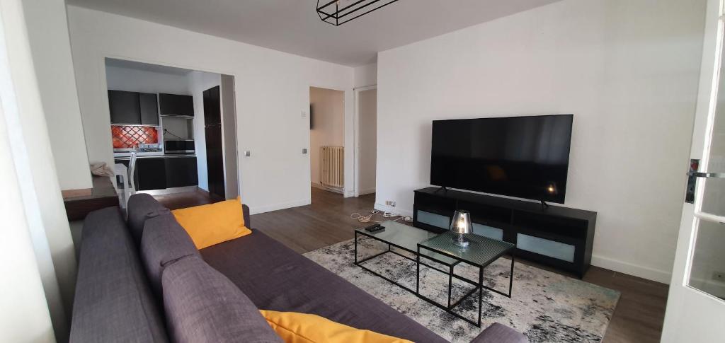 un salon avec un canapé et une télévision à écran plat dans l'établissement Appartement entier au dessus de villa, climatisation réversible poêle à bois tres chaleureux , wi fi parking privée gratuit situation 500 m, plage et centre ville, à Sanary-sur-Mer