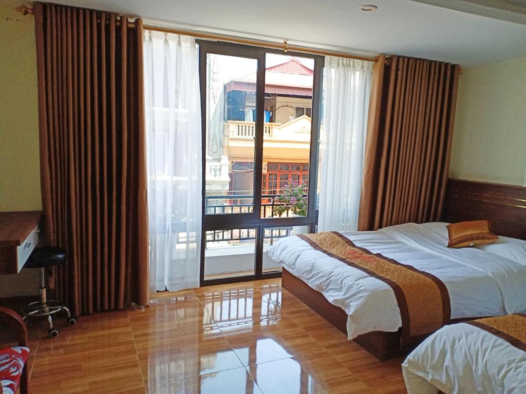 een hotelkamer met 2 bedden en een groot raam bij Orchids Hotel in Sa Pa