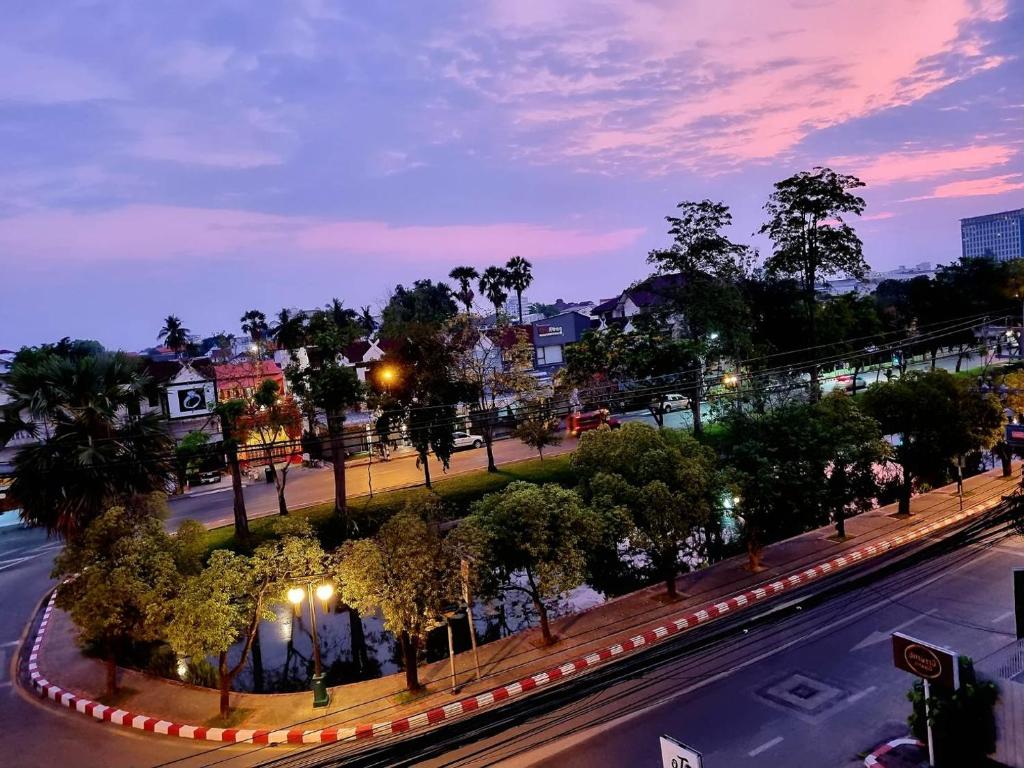 una calle de la ciudad con árboles y luces por la noche en T2B Hostel en Chiang Mai