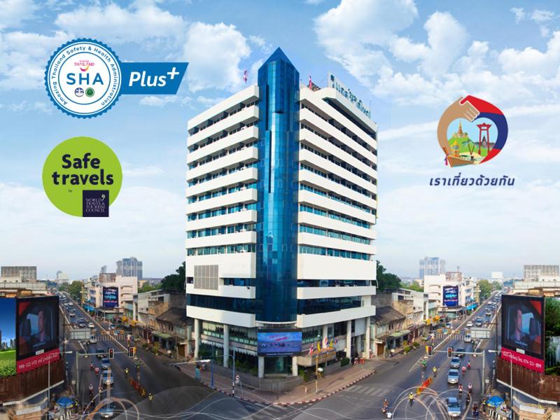 a tall blue building on a city street with traffic at V.L. Hatyai Hotel in Hat Yai