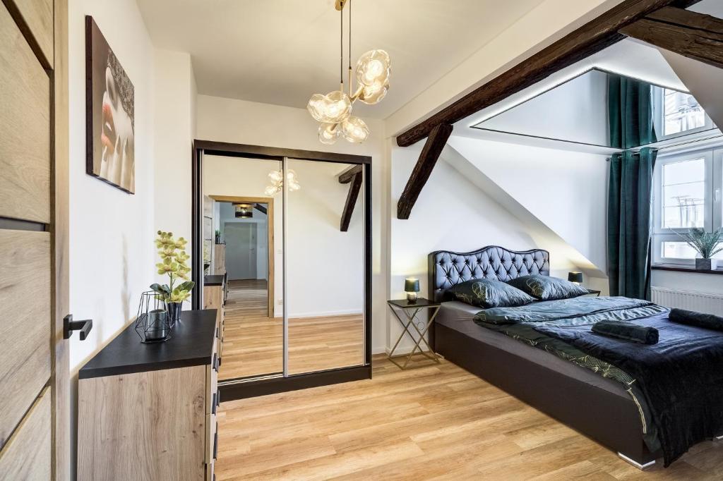 a bedroom with a king sized bed and a staircase at Przy Deptaku in Nowy Sącz