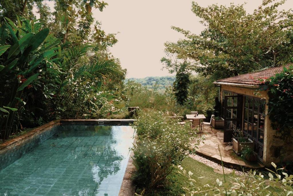 einen Pool inmitten eines Gartens in der Unterkunft Villa Sunset Jogjakarta in Yogyakarta