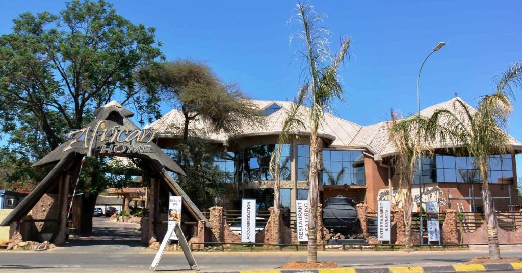 a hotel with a sign in front of a building at African Home Hotel in Gaborone