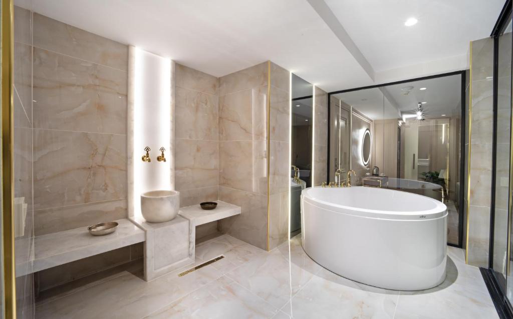 a bathroom with a white tub and a shower at Walton Gardens Pera in Istanbul