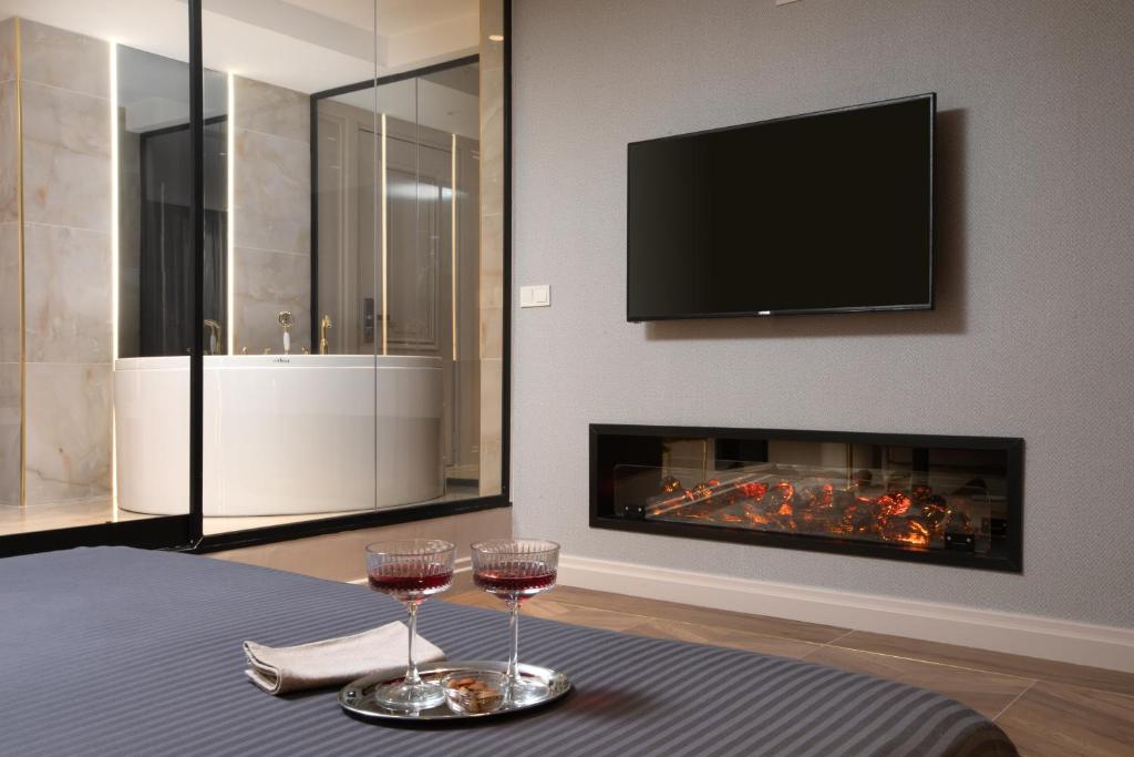 two glasses of wine on a table in front of a fireplace at Walton Gardens Pera in Istanbul
