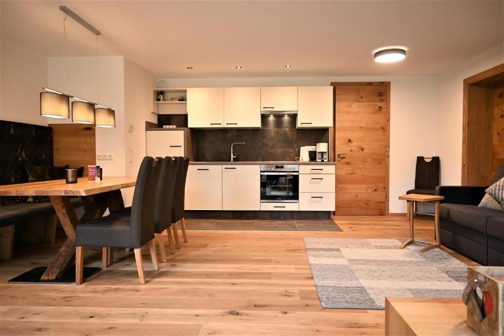 Residence Martha في ببيرفيير: مطبخ وغرفة معيشة مع طاولة وأريكة
