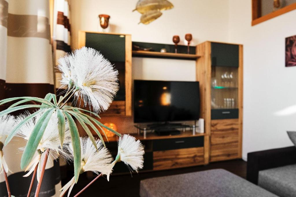 een woonkamer met een plant voor een tv bij Ferienhaus am Millibach in Wehingen