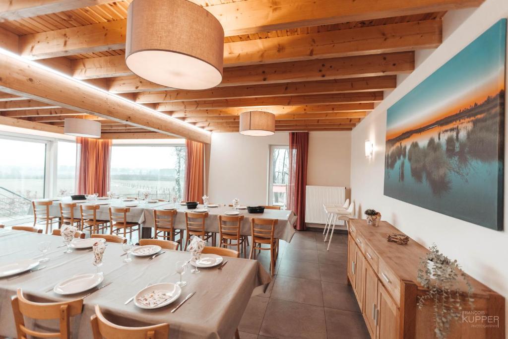 a dining room with a long table and chairs at Le Loup Gris - 35 pers - Vue-Wellness, Butgenbach-Malmedy in Butgenbach