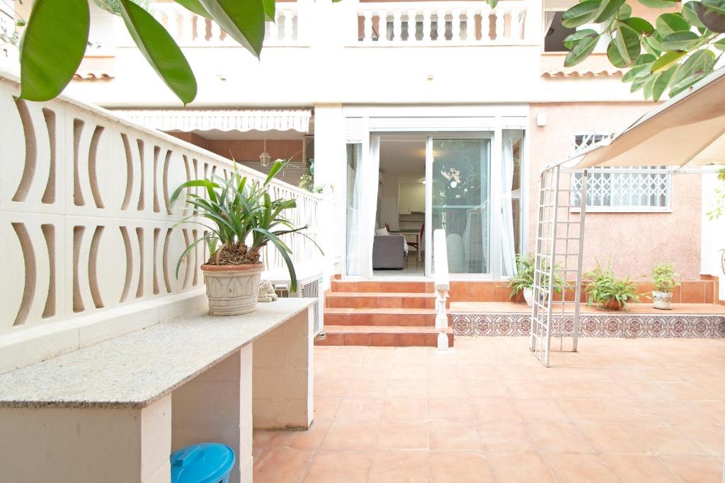 une terrasse couverte d'une maison avec un banc et des plantes dans l'établissement Global Properties, Apartamento 2 dormitorios en Canet d'en Berenguer, à Canet d'En Berenguer