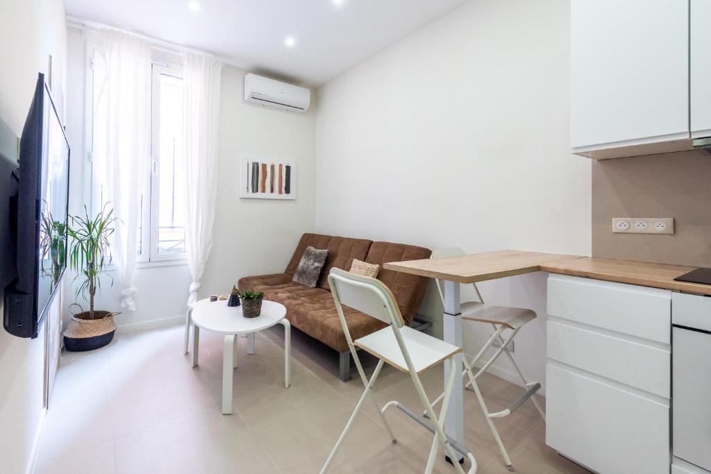 uma sala de estar com um sofá e uma mesa em Cozy appartement Juan-Les-Pins - 300m Plage em Juan-les-Pins