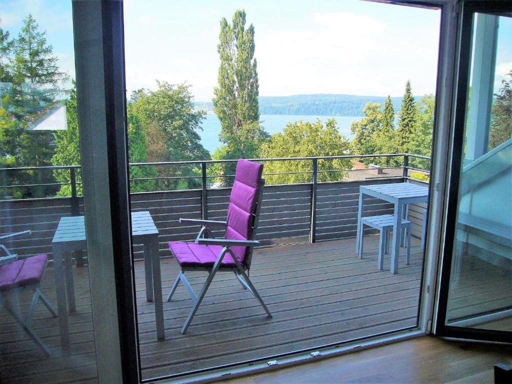 uma cadeira roxa e uma mesa na varanda em Apartments am Rehgehege Apartment 5 3 OG em Überlingen