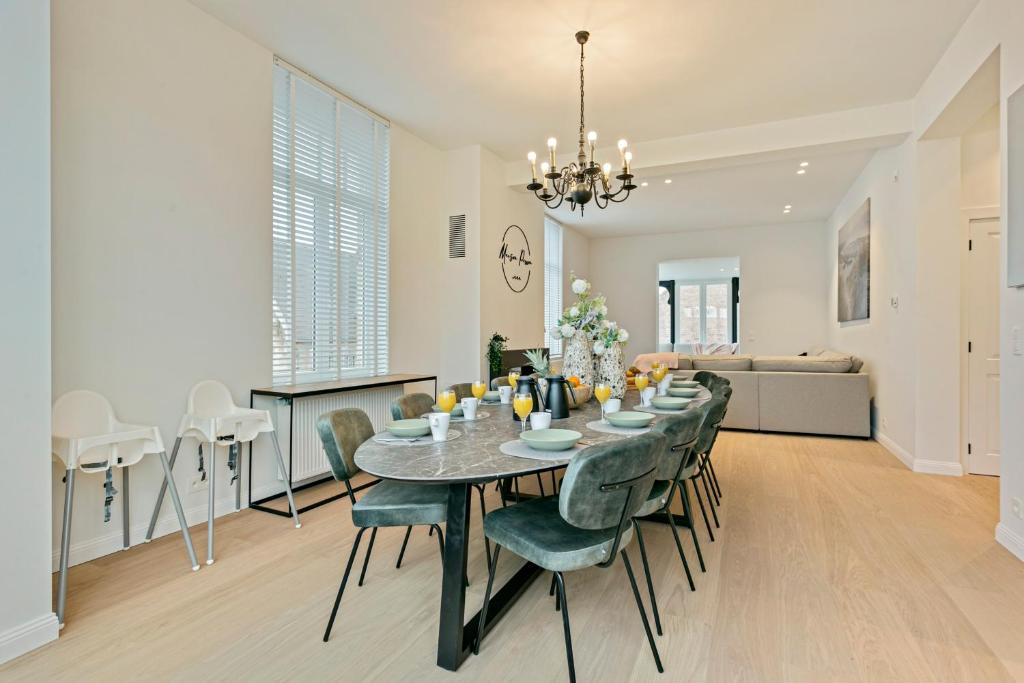 une salle à manger et un salon avec une table et des chaises dans l'établissement Maison Perron, à La Panne