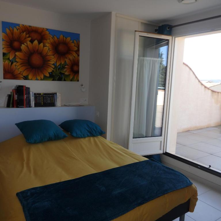 a bedroom with a bed and a large window at L&#39;oustal des Fontanilles in Castelnaudary