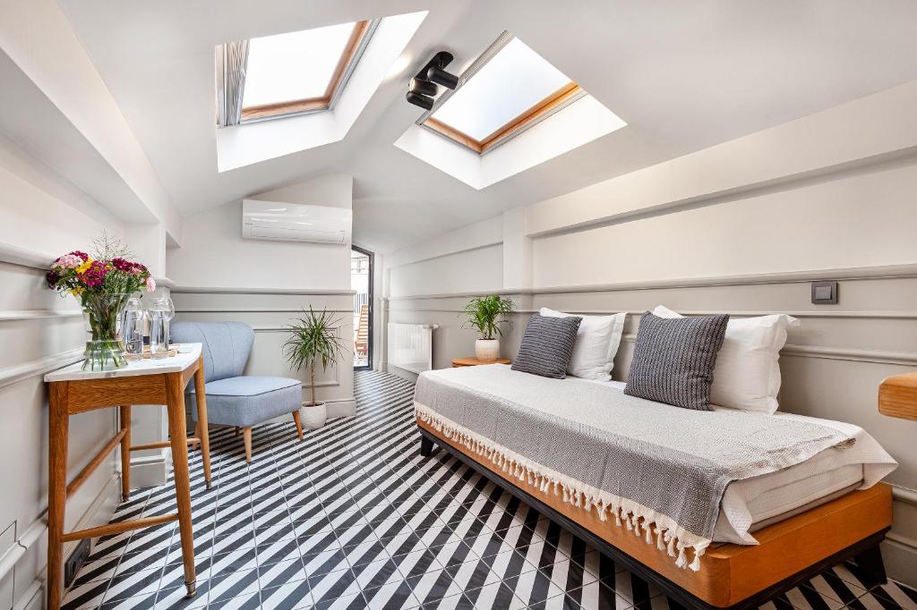 a bedroom with a bed and a desk and windows at World House Boutique Hotel Galata in Istanbul