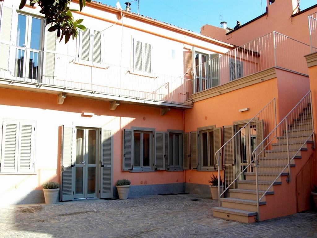 un edificio arancione e bianco con scale sopra di Residenza il Nespolo - Estella Hotel Collection a Torino