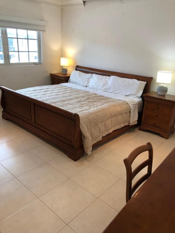 a bedroom with a large bed and two tables and a chair at Casa Duplex Privada con Piscina with Ride from Airport in Panama City