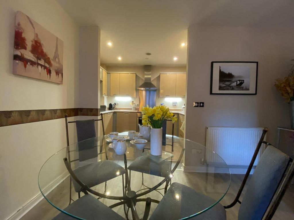 a dining room with a glass table and chairs at Roman Quarter apartment in Chichester