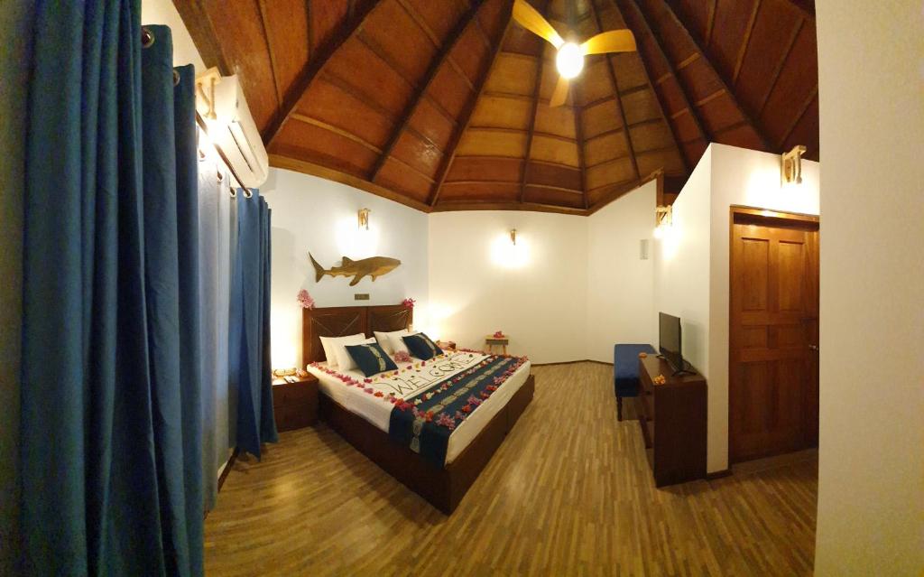 a bedroom with a bed and a wooden ceiling at Blue World Dharavandhoo in Dharavandhoo