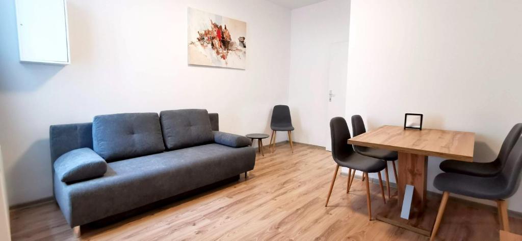 ein Wohnzimmer mit einem Sofa, einem Tisch und Stühlen in der Unterkunft Bacher Apartment in Wien