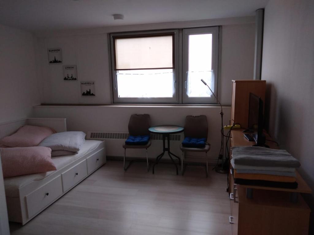 a bedroom with a bed and a table and a window at Studio-Apartment, zentral gelegen in Cologne