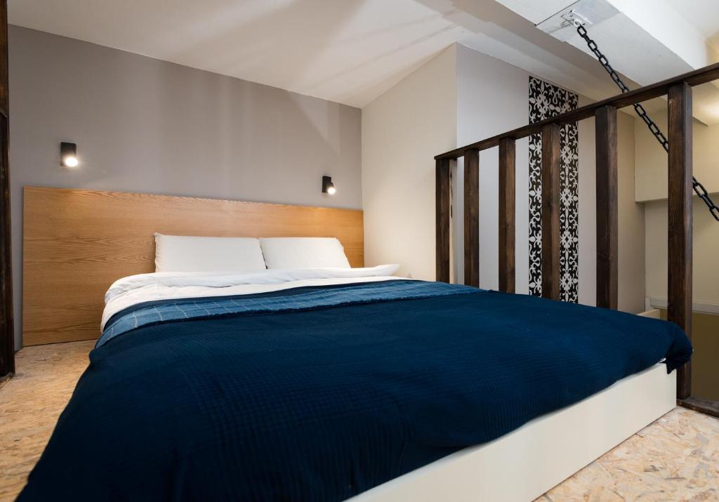 a bedroom with a large bed with blue sheets at Aju Ben Yehuda 42 in Jerusalem