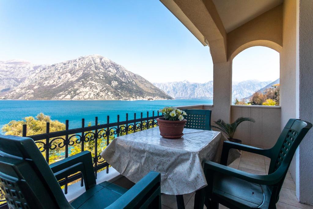 einen Tisch auf einem Balkon mit Blick auf das Wasser in der Unterkunft La Castagna Apartments in Kotor