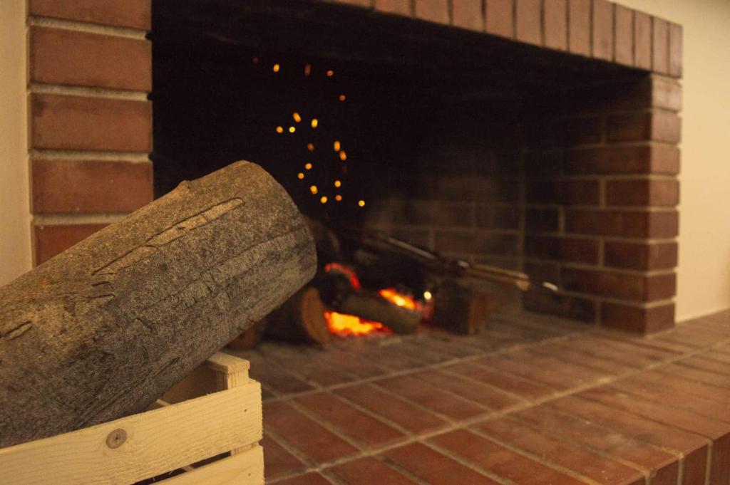 a brick fireplace with a fire in it at PURA B&b in Noicattaro