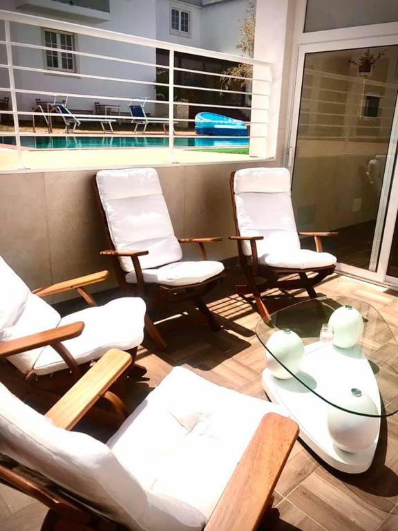 three chairs and a table in front of a window at PURA B&b in Noicattaro