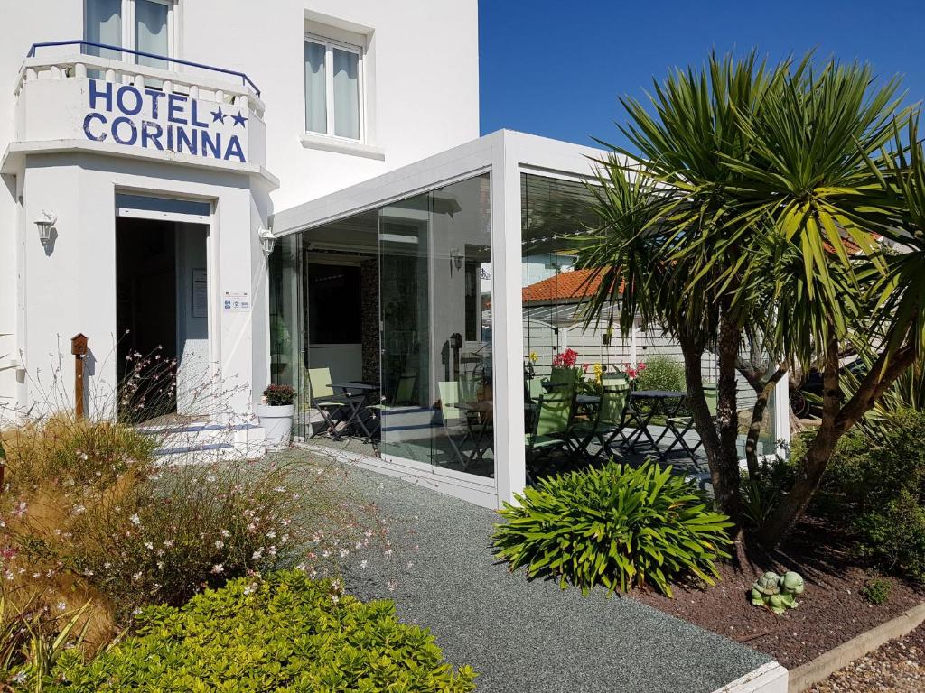 un hotel corina con una palmera frente a un edificio en The Originals Access, Hôtel Corinna, Royan en Royan