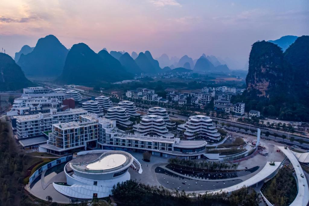 eine Luftansicht auf eine Stadt mit Bergen und Gebäuden in der Unterkunft Wingate By Wyndham Yangshuo in Guilin