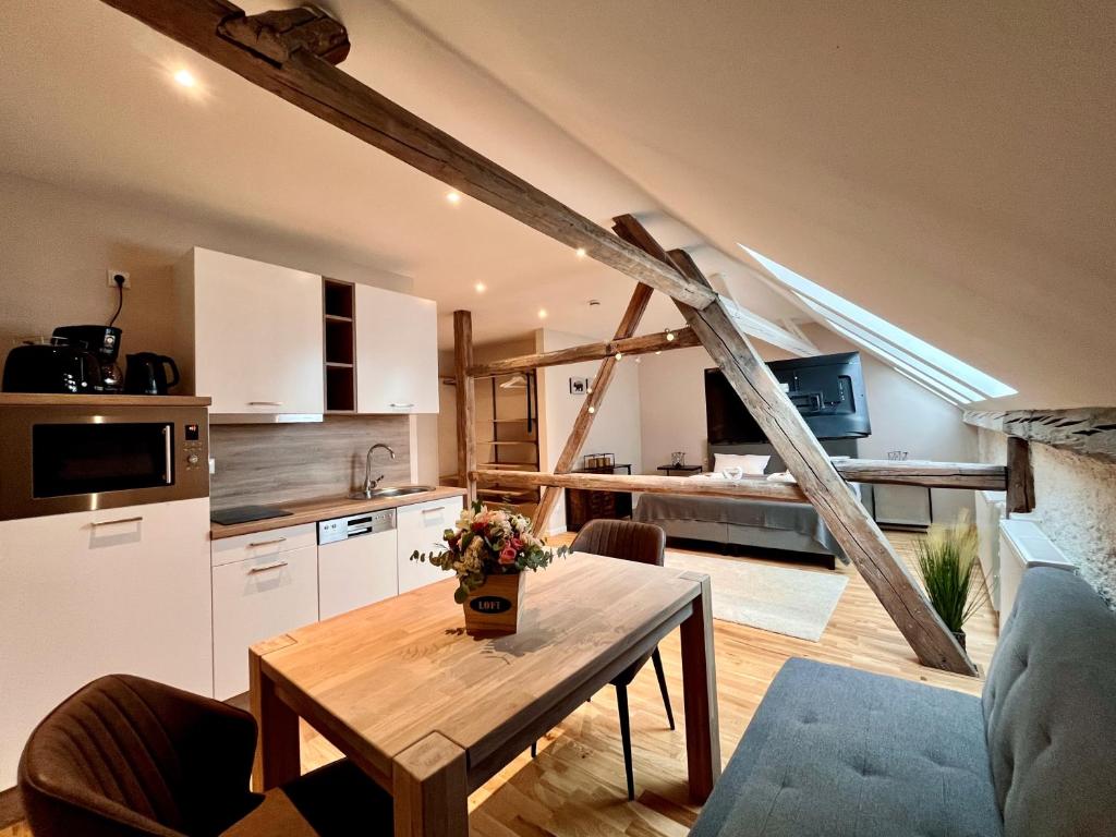 eine Küche und ein Wohnzimmer mit einem Holztisch in der Unterkunft Chalet & Apart Fichtelberger Blick in Kurort Oberwiesenthal