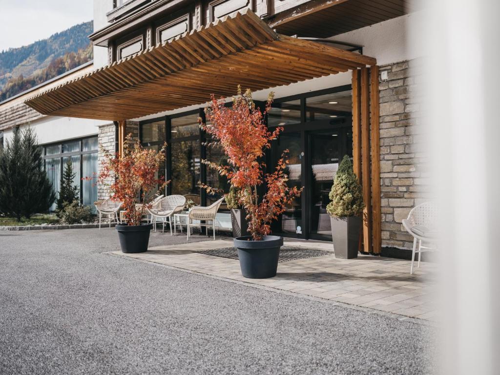 un grupo de plantas en macetas sentadas fuera de un edificio en Hotel Victoria by VAYA en Kaprun