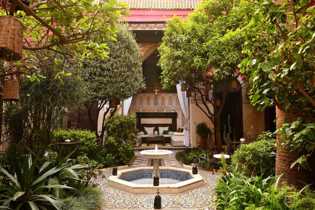 a garden with a fountain in the middle of a courtyard at Riad L'Aziza in Marrakesh