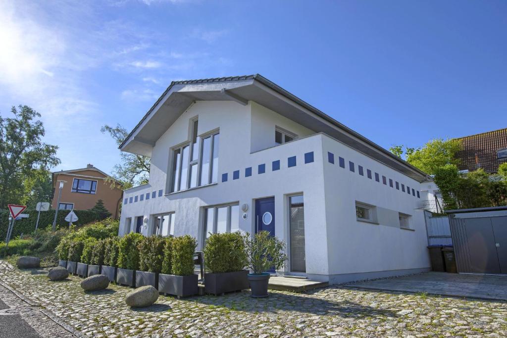 a white house with some plants in front of it at schöner Meerblick von der Dachterrasse Haus Ostseeblick 1 FeWo Meehrblick in Lohme