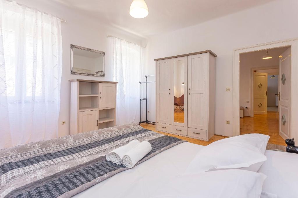a bedroom with a large bed with two towels on it at Old Market Residence in Šibenik