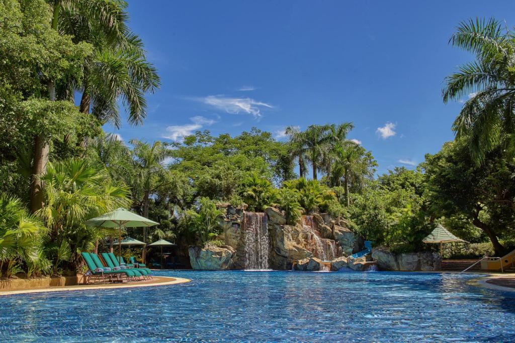 a swimming pool with trees and palm trees at Artyzen Grand Lapa Macau (formerly Grand Lapa Macau) in Macau