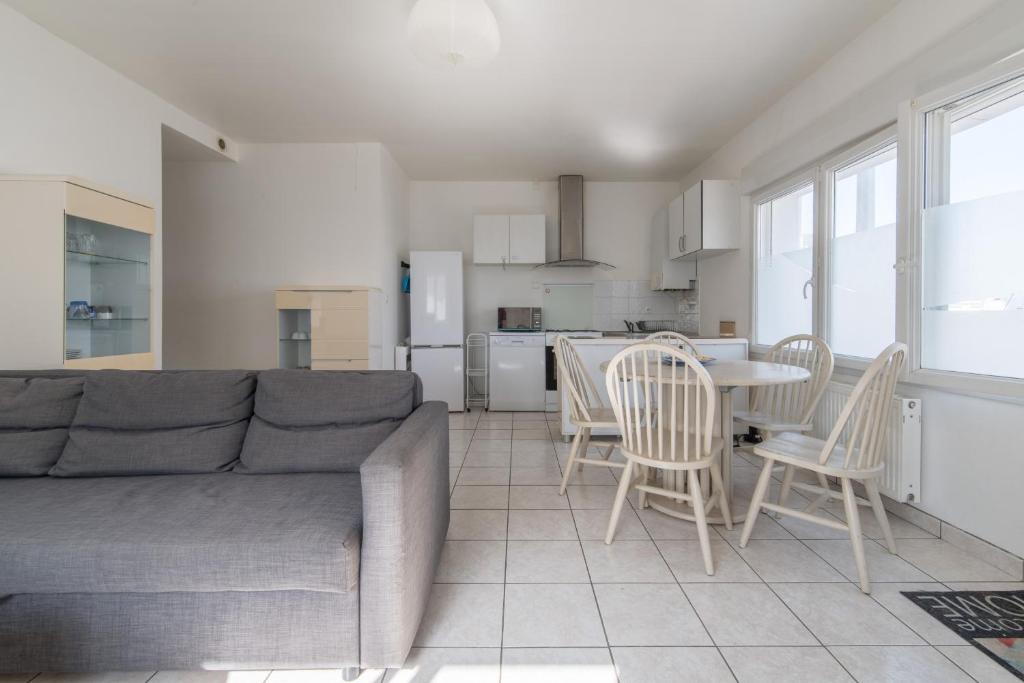 - un salon avec un canapé, une table et des chaises dans l'établissement LES CELTES - Appartement pour 6, à Saint-Nazaire
