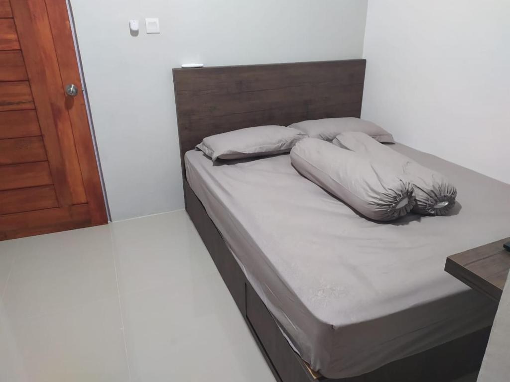 a bed with two pillows on it in a room at Rooms at Josapa Guest House in Batam Center