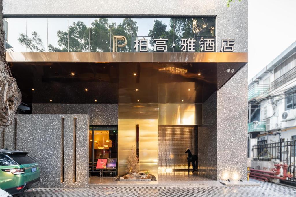 un hombre está parado fuera de un edificio en Paco Hotel Canton Tower Pazhou en Guangzhou