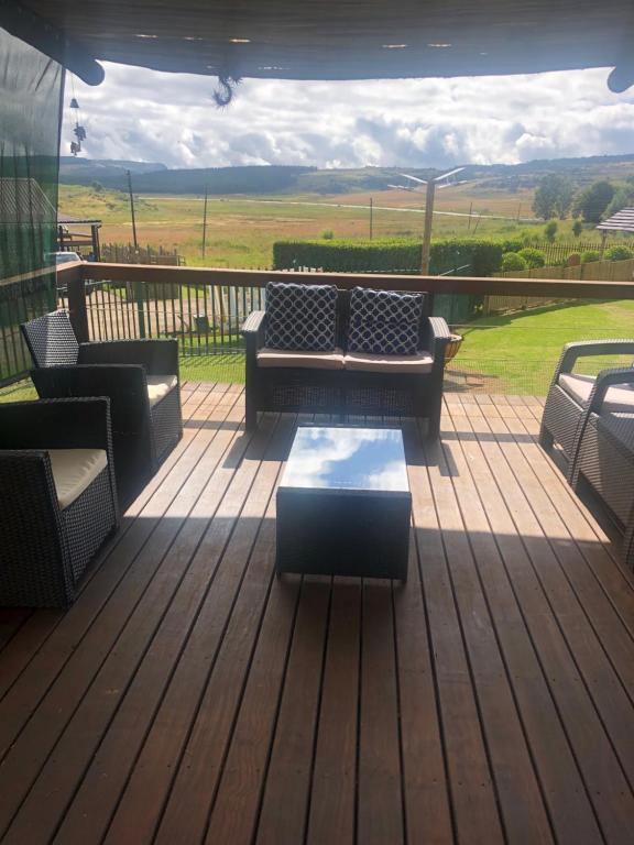a deck with couches and a coffee table on a porch at Le Bella Dons in Graskop