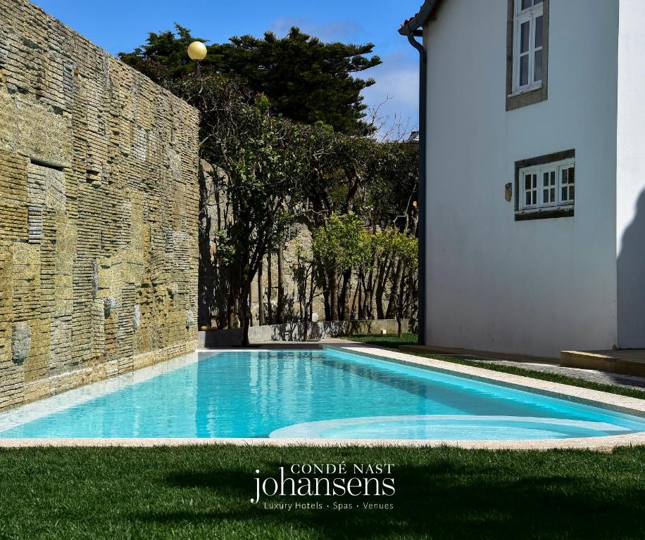 a swimming pool in front of a stone building at Casa Melo Alvim - by Unlock Boutique Hotels in Viana do Castelo