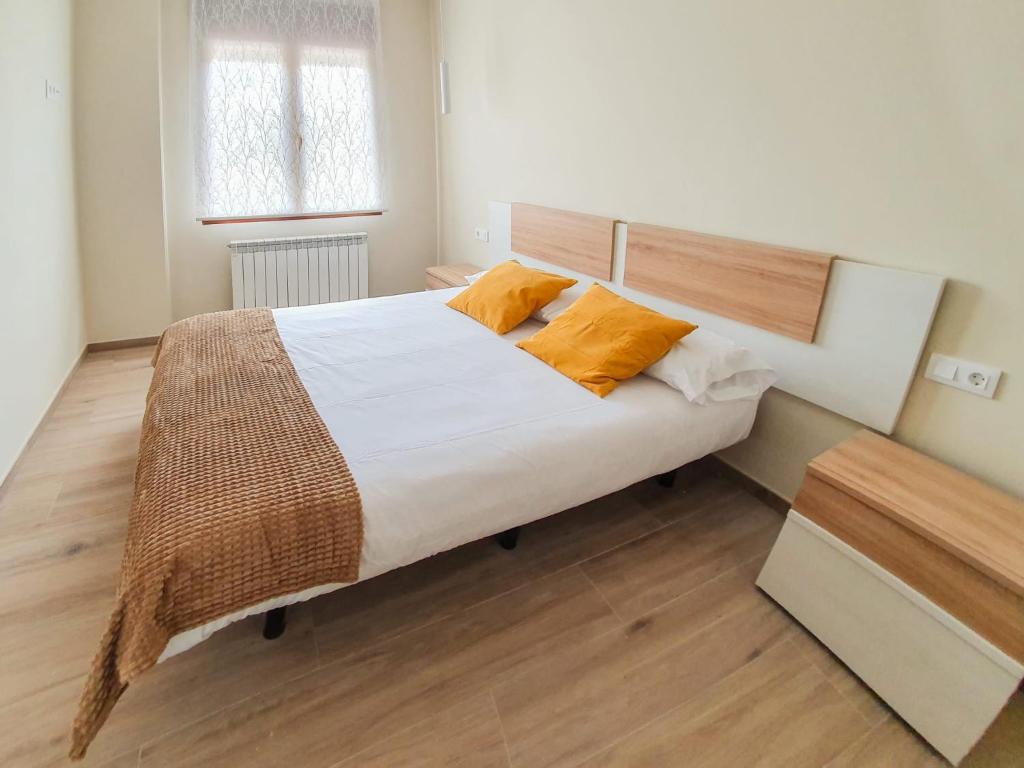 - une chambre avec un grand lit et des oreillers orange dans l'établissement DOMVS I, à El Burgo de Osma